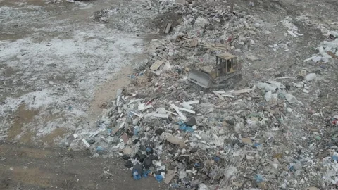 Bulldozer tractor pushes garbage from a mountain in a city dump Stock-Footage 148657588