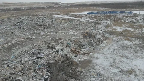 Bulldozer tractor pushes garbage from a mountain in a city dump Stock Footage 148657998
