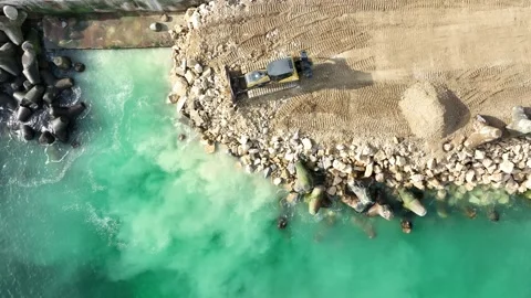 Bulldozer working on a breakwater construction Stock Footage 255554708