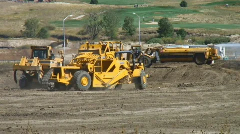 Bulldozers and scrapers move dirt Stock Footage