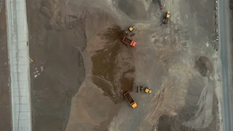 Bulldozers load crushed stone onto dump trucks. View from the drone to the Stock Footage 160596038