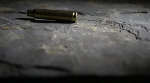 Bullet casing falls to ground, slow motion Stock Footage 55764787