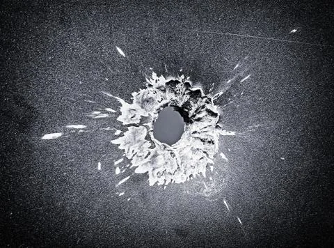 Bullet hole in the metal plate, black and white photo Stock Photos