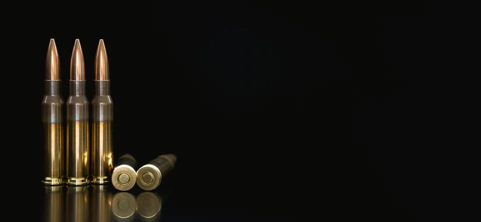 Bullet isolated on black background with reflexion. Rifle bullets close-up on Stock Photos