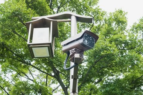Bullet security camera with traditional design monitors chinese urban park. s Stock Photos