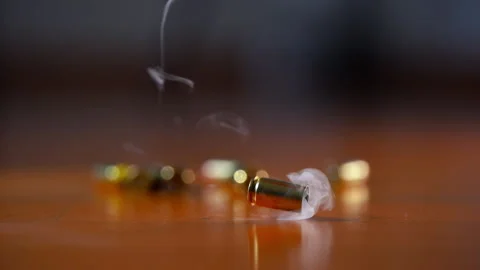 Bullet shell casing falling to wooden surface in slow motion. Fired brass casing Stock Footage 334021474