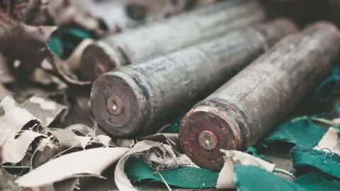 Bullet shells from heavy machine gun on the table with camouflage netting Stock Photos