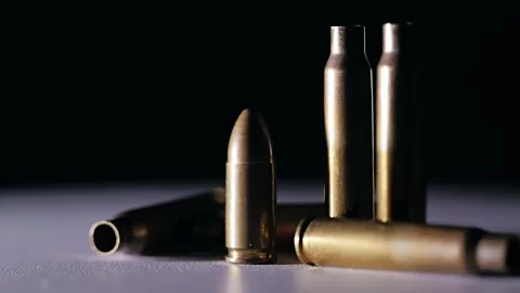 Bullet Spins Beside Empty Shells In Factory Light, Symbol Of War Industry Stock Footage 319061964