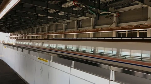 A bullet train speeds through a train station Stock Footage 99429322