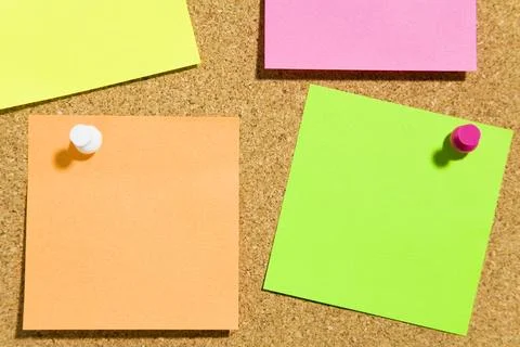 Bulletin board and multi colored stickies attached with push pins. Copy space Stock Photos