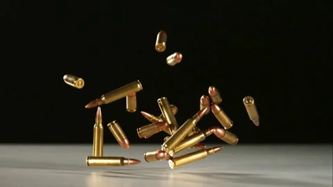 Bullets and casings fall on white surface Stock Footage 327178331