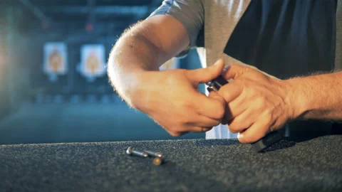 Bullets are getting put into a magazine by a man Stock Footage 98890809