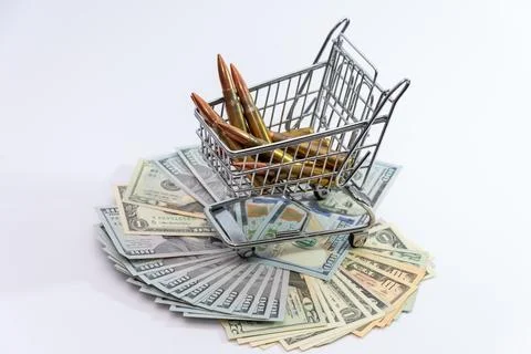 Bullets in a cart placed on dollars reflect profit from war and commerciali.. Photos
