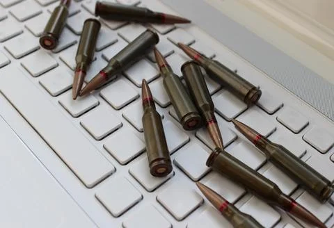 Bullets Cartridges Scattered on an Empty Keys of Laptop Keyboard 스톡 사진