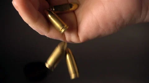 Bullets fall from man's hand, slow motion Stock Footage 61696217