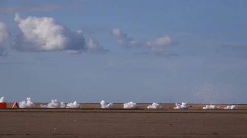 Bullets from machine gun hitting sand black smoke UK 4k Stock Footage 115958470