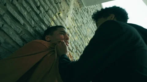 Bully cornering scared guy in a dark alley, aggressive behavior, street violence Stock Footage 205929585
