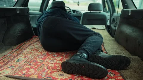 Bum man sleeping in back of car, lying on rug in station wagon trunk, showing Stock Footage 323910775