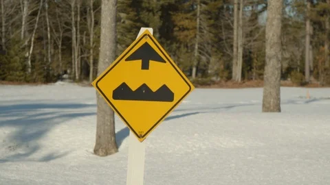 Bump ahead sign on side of road during winter, tracking 4k shot 動画素材 120654744
