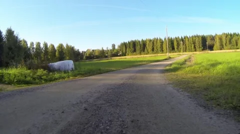 Bumper camera view of car driving on countryside gravel road Stock Footage 55493195