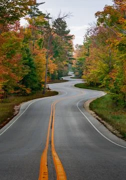 Bumpy curvy road through an autumn forest in Door County, Wisconsin, the USA Stock Photos