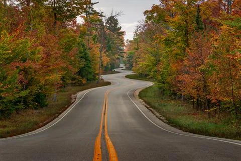 Bumpy curvy road through an autumn forest in Door County, Wisconsin, the USA Stock Photos