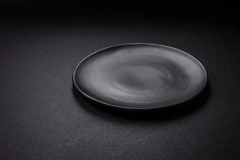 Bumpy empty ceramic plate on a textured concrete background Stock Photos