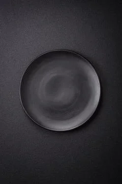 Bumpy empty ceramic plate on a textured concrete background Stock Photos