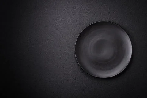 Bumpy empty ceramic plate on a textured concrete background 写真素材