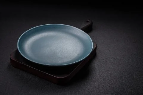 Bumpy empty ceramic plate on a textured concrete background Stock Photos