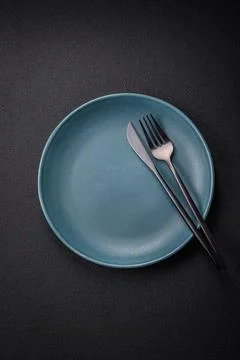 Bumpy empty ceramic plate on a textured concrete background 写真素材