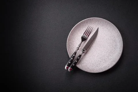 Bumpy empty ceramic plate on a textured concrete background Stock Photos
