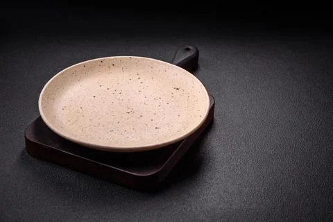 Bumpy empty ceramic plate on a textured concrete background Stock Photos