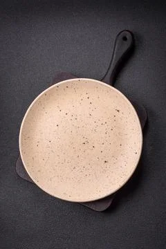 Bumpy empty ceramic plate on a textured concrete background Stock Photos