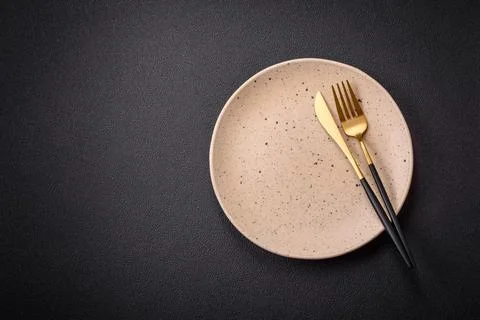 Bumpy empty ceramic plate on a textured concrete background 写真素材