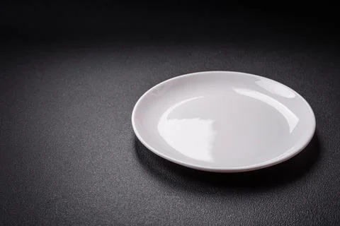 Bumpy empty ceramic plate on a textured concrete background 스톡 사진