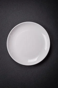 Bumpy empty ceramic plate on a textured concrete background 스톡 사진