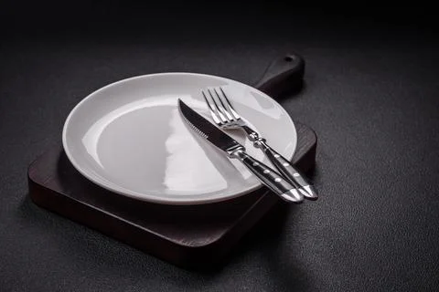 Bumpy empty ceramic plate on a textured concrete background Stock Photos