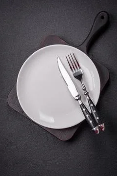 Bumpy empty ceramic plate on a textured concrete background 스톡 사진