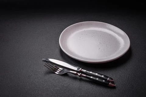 Bumpy empty ceramic plate on a textured concrete background 스톡 사진