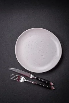 Bumpy empty ceramic plate on a textured concrete background 스톡 사진