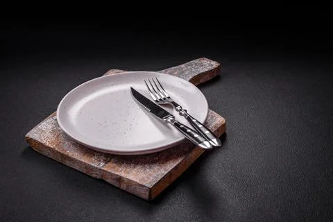 Bumpy empty ceramic plate on a textured concrete background 写真素材