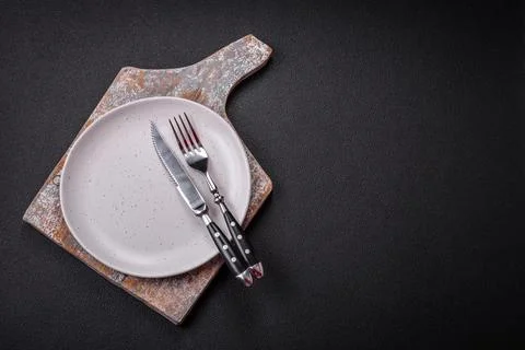 Bumpy empty ceramic plate on a textured concrete background 스톡 사진