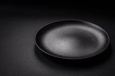 Bumpy empty ceramic plate on a textured concrete background Stock Photos