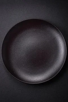 Bumpy empty ceramic plate on a textured concrete background 写真素材