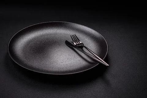 Bumpy empty ceramic plate on a textured concrete background 스톡 사진