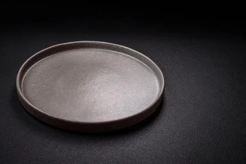 Bumpy empty ceramic plate on a textured concrete background Stock Photos