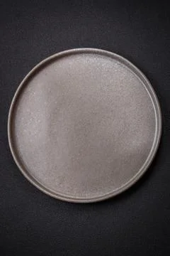 Bumpy empty ceramic plate on a textured concrete background Stock Photos