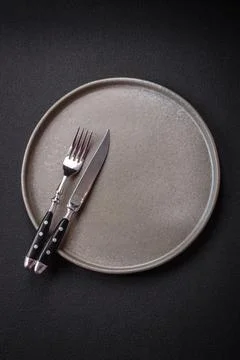 Bumpy empty ceramic plate on a textured concrete background Stock Photos