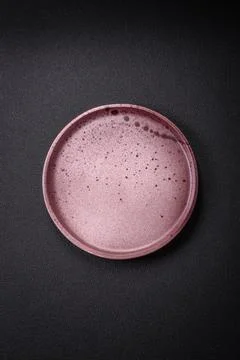 Bumpy empty ceramic plate on a textured concrete background 写真素材